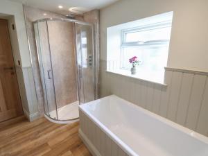 a white bathroom with a shower and a tub at Hollywood Cottage in Barnard Castle +34 photos