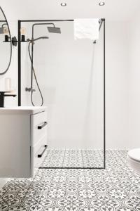 a bathroom with a shower and a tile floor at Urocza Art Pensjonat in Krynica Zdrój +58 photos