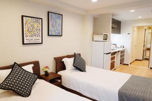 a hotel room with two beds and a kitchen at 有朋ハウス 301 in Osaka