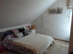 a bedroom with a bed with a blanket and a window at La Vie en Bleue en Pays Melois in Saint-Julien-sur-Sarthe