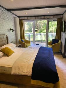 a bedroom with a large bed and a balcony at Pet Friendly Lodge - Sleeps6 - Long Stay Discount in Fordingbridge