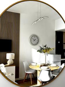 a mirror reflecting a dining room with a table and chairs at Castlegreen Lux Apartment in Dumbarton +20 photos