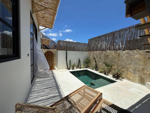 a backyard with a swimming pool and a stone wall at Blue Origin Bali in Munggu