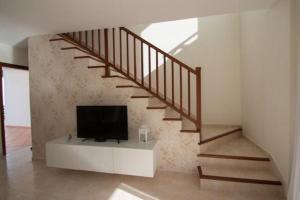 a living room with a tv and a staircase at Apartamentos Quintana in Playa Blanca