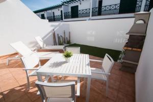 a white table and chairs on a balcony at Apartamentos Quintana in Playa Blanca