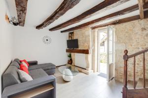 ein Wohnzimmer mit Sofa und Fernseher in der Unterkunft Maison moderne, en pierre avec terrasse pour 6 in Montignac