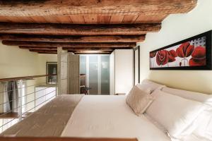 una camera da letto con un letto bianco e un soffitto in legno di Borgovico 42 by Quokka 360 - near the train station of Como a Como