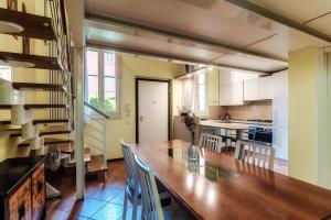 una cucina con un lungo tavolo in legno e sedie di Borgovico 42 by Quokka 360 - near the train station of Como a Como