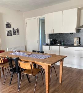 Una cocina con una mesa y sillas de madera. en Bungalow Buitenlui, en Molenschot