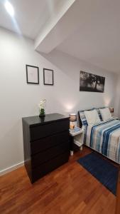 a bedroom with a bed and a dresser at Maligueira Apartment in Leiria