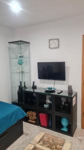 a entertainment center with a flat screen tv in a living room at Maligueira Apartment in Leiria
