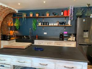 a kitchen with a counter top and a refrigerator at The Hollow Wood in Lyndhurst