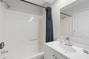a white bathroom with a sink and a mirror at Willow Inn Suites in Eau Claire