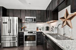 a kitchen with stainless steel appliances and black cabinets at 2BR Condo with Balcony, Free Tix, Walk to Downtown in Asheville