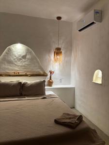 a bedroom with a bed and a pendant light at Araxá Milagres in São Miguel dos Milagres