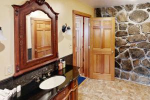 a bathroom with a sink and a stone wall at Justin Lake Lodge in Londonderry +73 photos