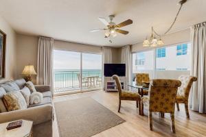 a living room with a couch and a table with a view at Pelican Isle 418 in Fort Walton Beach