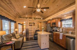 a kitchen and living room in a log cabin at Lakeview 2BR Tiny Home near Trails and Bocce in Flat Rock