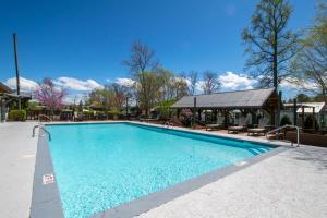 a swimming pool at a resort with chairs and a building at Lakeview 2BR Tiny Home near Trails and Bocce in Flat Rock