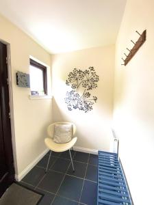 a room with a chair and a sticker on the wall at Lochindaal - Beautiful, Spacious 4 Bedroom House in Kintyre in Whitehouse