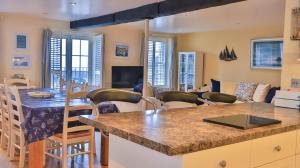 a kitchen and living room with a table and chairs at Harbourside Apartment in Mevagissey