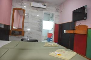 a room with a bed and a mirror and a tv at hotel prashant international in Gandhidham