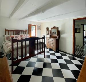 a bedroom with a bed and a checkerboard floor at Murrayfield Karoo Guest Villa in Nieu-Bethesda