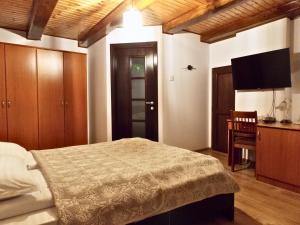 a bedroom with a bed and a flat screen tv at Casa Opal in Săcele
