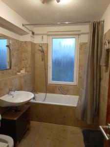 Un baño con bañera, lavabo y ducha. en Luxury Apartment MESSE, en Hannover 72 fotos más