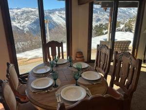 a table with plates and wine glasses and a large window at Aspen Chalet 976 in Aspen