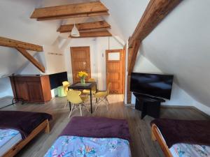 Un dormitorio con dos camas y una mesa con televisión. en Kwatery u Jarka z ogrodem i parkingiem, en Jelenia Góra