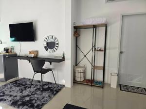 a room with a desk with a chair and a television at เลอร์กบินทร์ in Kabin Buri
