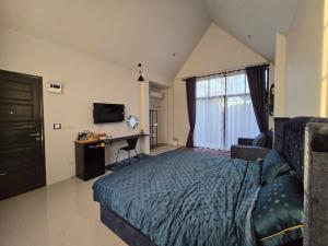 a bedroom with a bed and a desk and a television at เลอร์กบินทร์ in Kabin Buri +14 photos