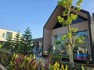 a house with a tree in front of it at เลอร์กบินทร์ in Kabin Buri