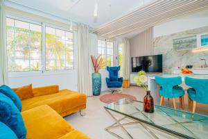 滨海帕尔姆Luxury 3bd villa with premium amenities, jacuzzi, private parking的客厅里有一张黄色的沙发和蓝色的椅子