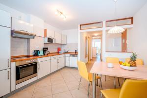 Una cocina y un comedor con mesa y sillas. en Residenz Meeresblick D Fewo 22, en Rerik 15 fotos más
