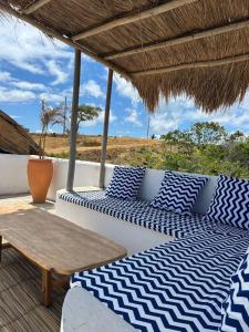 a porch with blue and white pillows and a table at Araxá Milagres in São Miguel dos Milagres
