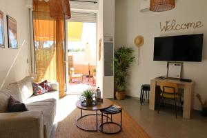 un salon avec un canapé et une télévision dans l'établissement Très bel appartement avec piscine en bord de mer, à Ajaccio