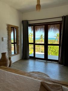 a bedroom with a large window with a view of the ocean at Araxá Milagres in São Miguel dos Milagres +105 photos