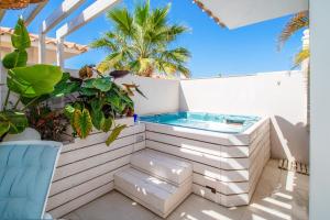 滨海帕尔姆Luxury 3bd villa with premium amenities, jacuzzi, private parking的棕榈树阳台的热水浴池