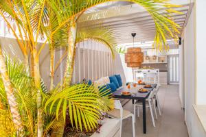 滨海帕尔姆Luxury 3bd villa with premium amenities, jacuzzi, private parking的一间设有桌子和棕榈树的用餐室