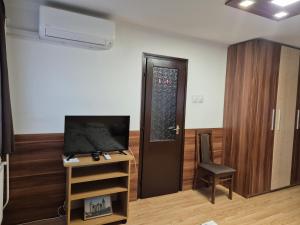 Pokój z drzwiami, telewizorem i krzesłem w obiekcie Crystal Sóstó Apartman w Nyíregyházie