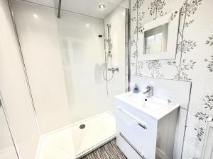 a white bathroom with a shower and a sink at Traditional Inveraray Cottage - Amazing Loch Views in Inveraray