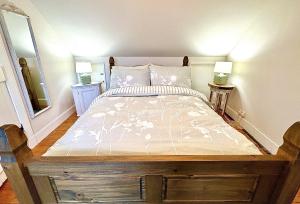 a bedroom with a bed with a wooden frame at Traditional Inveraray Cottage - Amazing Loch Views in Inveraray