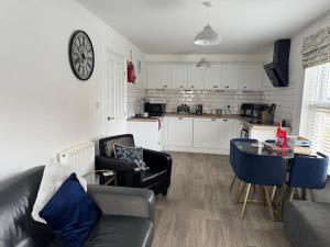 a living room with a couch and a table and a kitchen at Sunrise Cove, The Bay, Filey in Filey