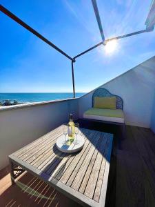un tavolo con una bottiglia di vino su un balcone di "La Casa da'Mare" un attico di charme vista mare ad Anzio
