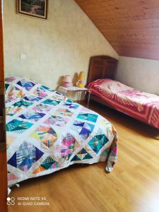 a bedroom with two beds and a quilt at 3 Chambres chez l'habitant in Valleiry