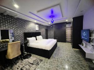 a bedroom with a bed and a tv in it at Auxano Apartments in Abuja