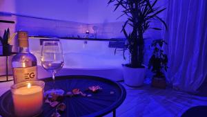 a candle and a table with a wine bottle and a bath tub at Majestic Salus Spa in Fiuggi