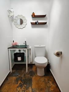 a bathroom with a toilet and a table with a mirror at Stressfree Suite in Vila Nova de Milfontes +33 photos